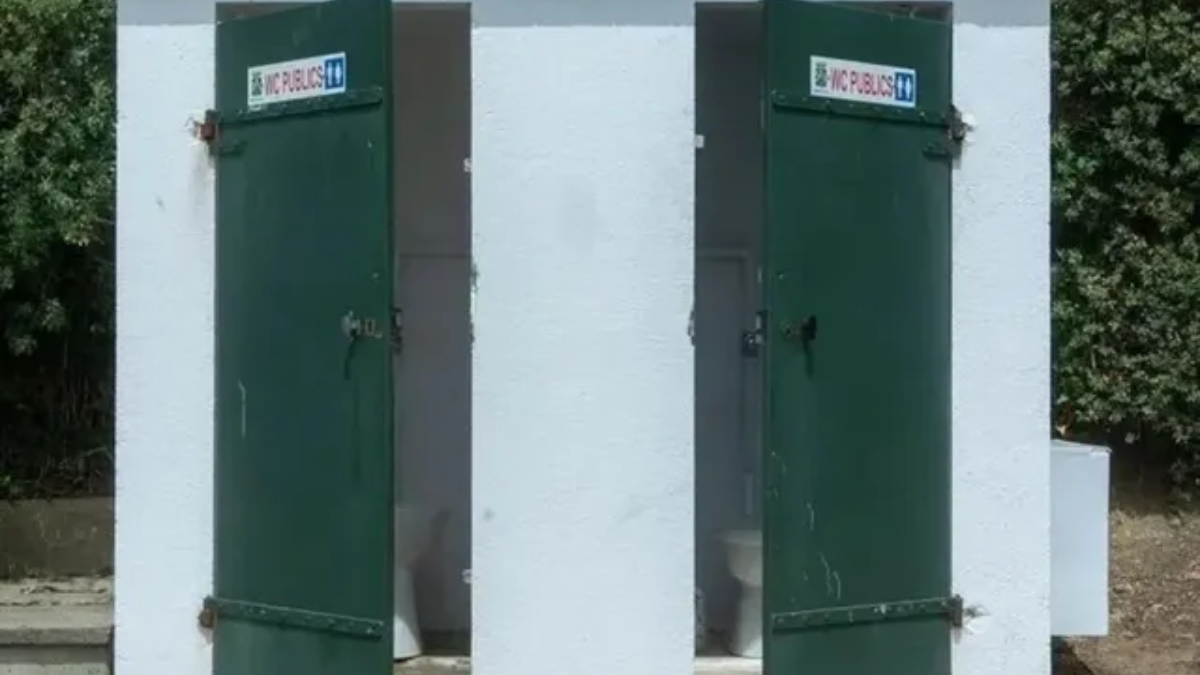 Government official explaining the Swachh Bharat Mission-2 toilet construction subsidy scheme in a Telangana village.